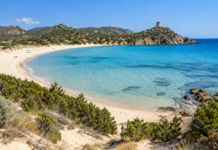 Chia beach with turquoise water, natural dunes and Torre di Chia in southern Sardinia