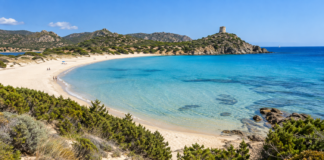 Chia beach with turquoise water, natural dunes and Torre di Chia in southern Sardinia